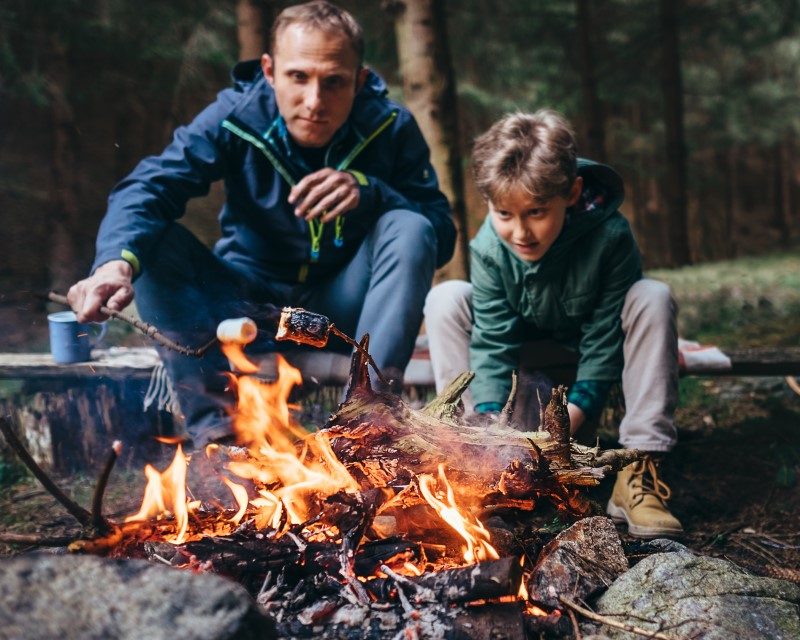 Father and son sitting around a campfire