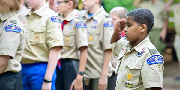 Image of Scouts saluting in uniform.