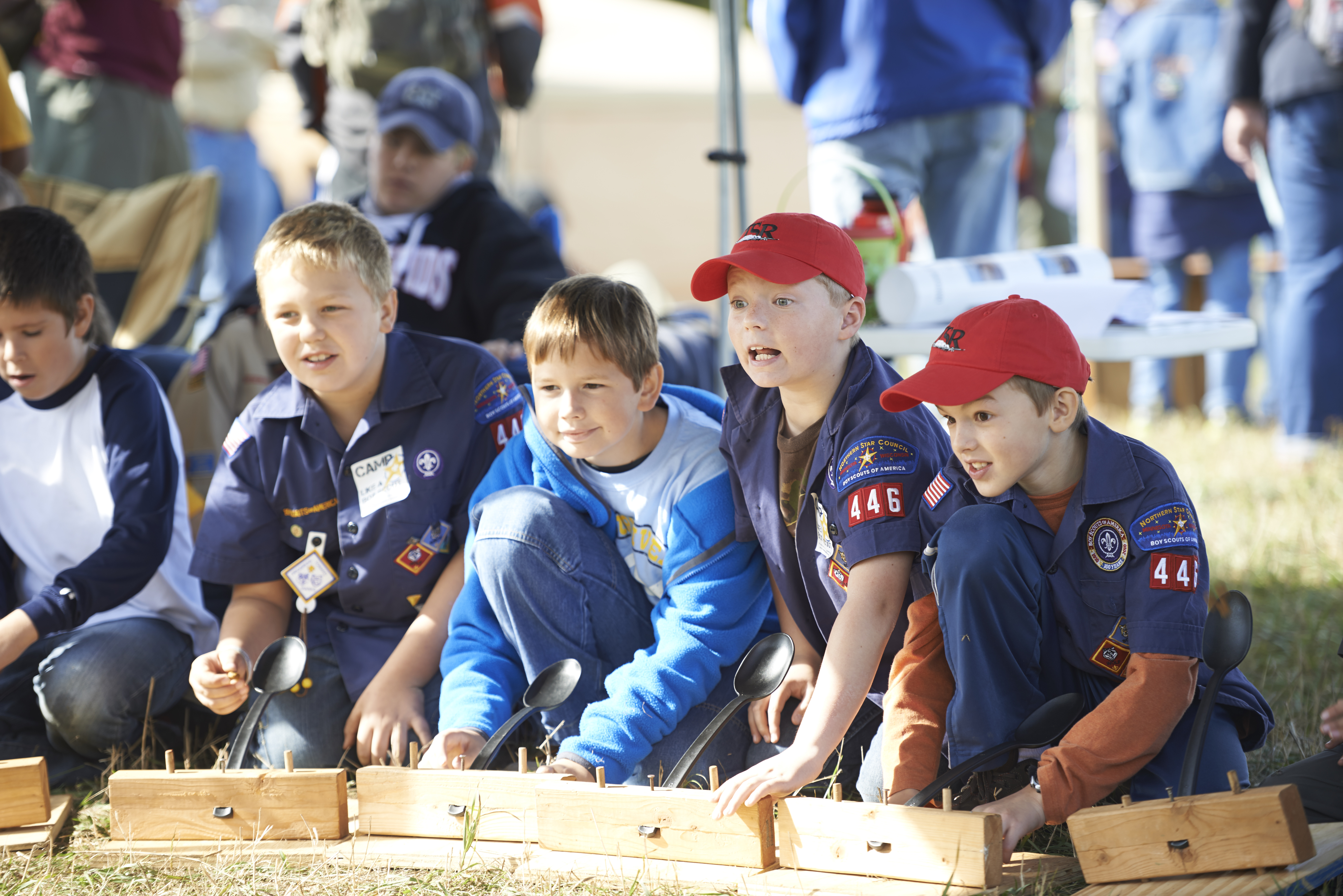 Group of Cub Scouts dressed in uniform watching an activity happen off camera