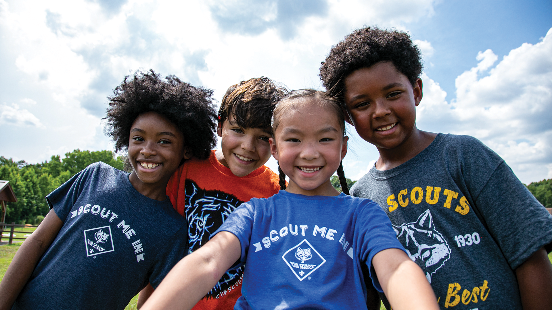 A selfie of 4 youth, 3 male and 1 female, wearing Cub Scouting shirts while smiling.