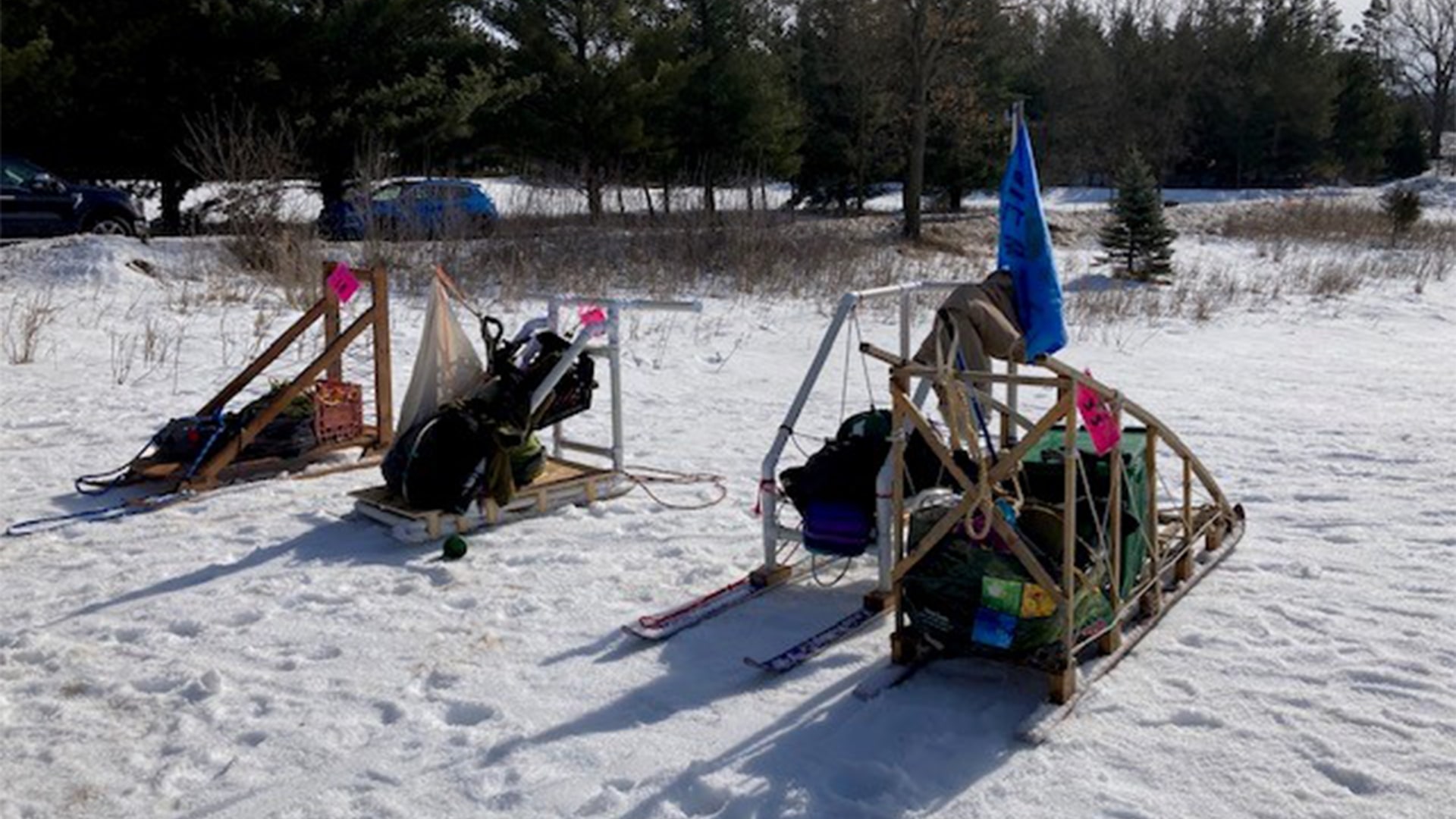 Four sleds of gear are packed and sitting on the snow while the Scouts are off doing an activity Four sleds of gear are packed and sitting on the snow while the Scouts are off doing an activity
