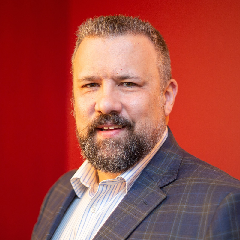 Nick Pedersen smiling while wearing a suit.
